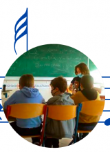 Photo ronde sur une portée musicale, d'enfants assis de dos dans une classe