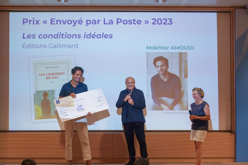 Photo de Mokhtar Amoudi recevant le prix Envoyé par La Poste (un chèque immense sur carton) des mains d'Olivier Poivre d'Arvor et d'Anne-Marie Jean