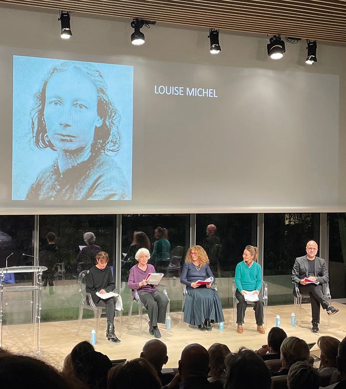 Photo des comédiennes assises et du récitant avec photo de Louise Michel projetée sur écran 