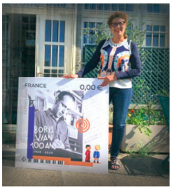 Nicole Bertolt pose avec le timbre postal Boris Vian 100 ans