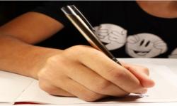 photo d'une main tenant un stylo qui écrit