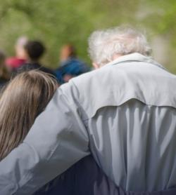 Photo de deux personnes de dos, une jeune et une personne âgée