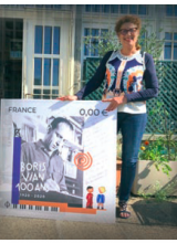 Nicole Bertolt pose avec le timbre postal Boris Vian 100 ans